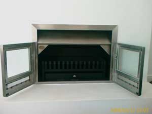 Mildsteel insert fireplace with stainless trim and doors